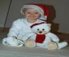 Oğlan oyuncak ayı ile Noel Baba şapkalı